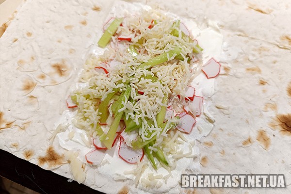 Кладемо огірок та посипаємо сиром